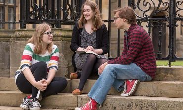 Students sitting on the steps of Merton College