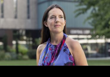 Professor Dame Molly Stevens, a middle-aged white woman with long brown hair, wearing a purple dress. 