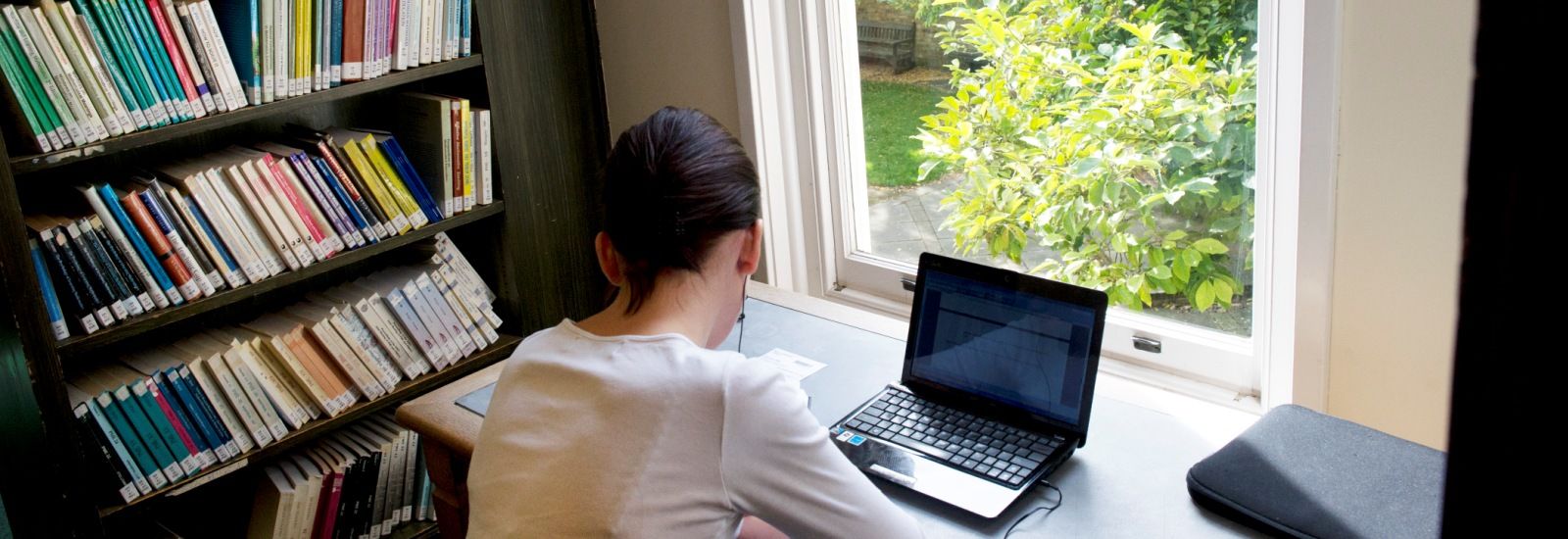 A student working at a laptop in a library