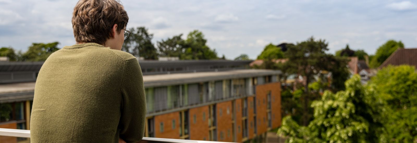 A student looking out from the balcony of the Dickson Poon building.