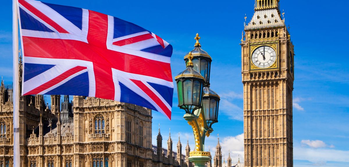 The Houses of Parliament, with a Union Jack flag in the foreground. Image credit: Shutterstock.